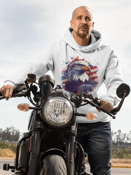 Bearded man on a motorcycle wearing a white hoodie with patriotic bald eagle design – American biker style by Rugged Rhythm.
